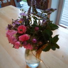 Colorful watercolor painting of glass vase with flowers by window