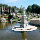 Manicured garden with red roses, fountains, white architecture