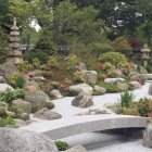 Snow-covered Japanese garden with pagoda structures and stepping-stone path