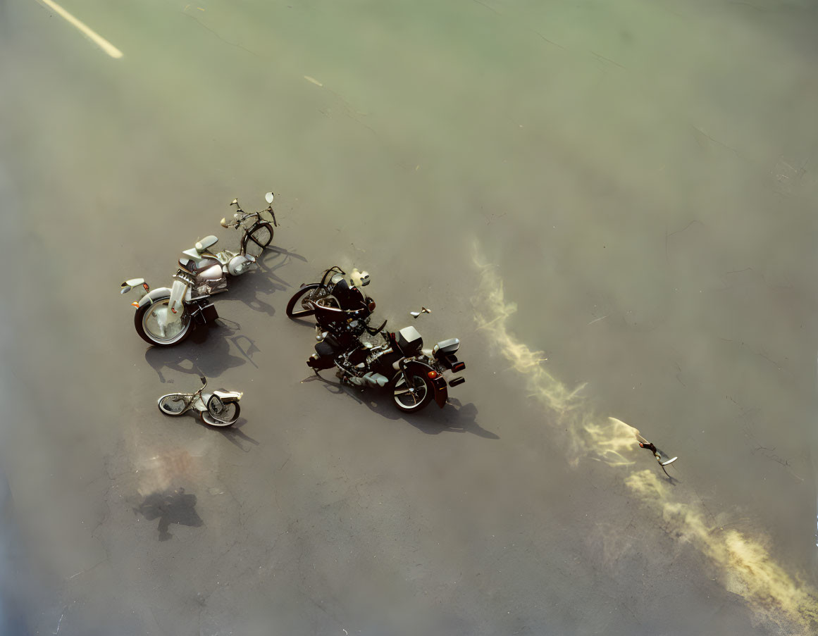 Motorcycles and bicycle parked on concrete with long shadow.