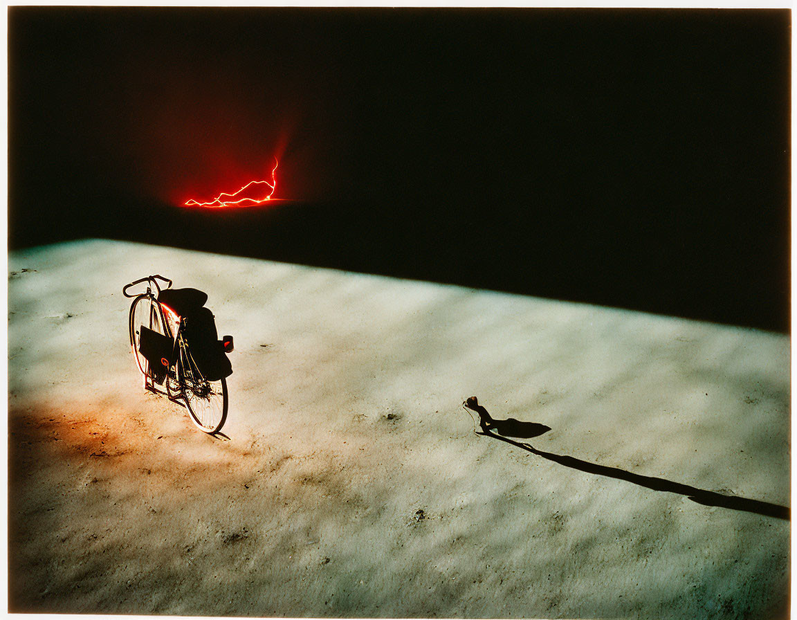 Parked Bicycle Casting Long Shadow on Textured Ground