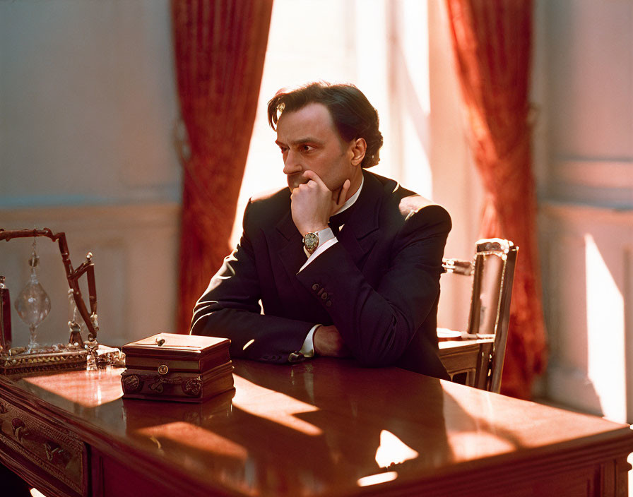 Man in Dark Suit Contemplating at Polished Table