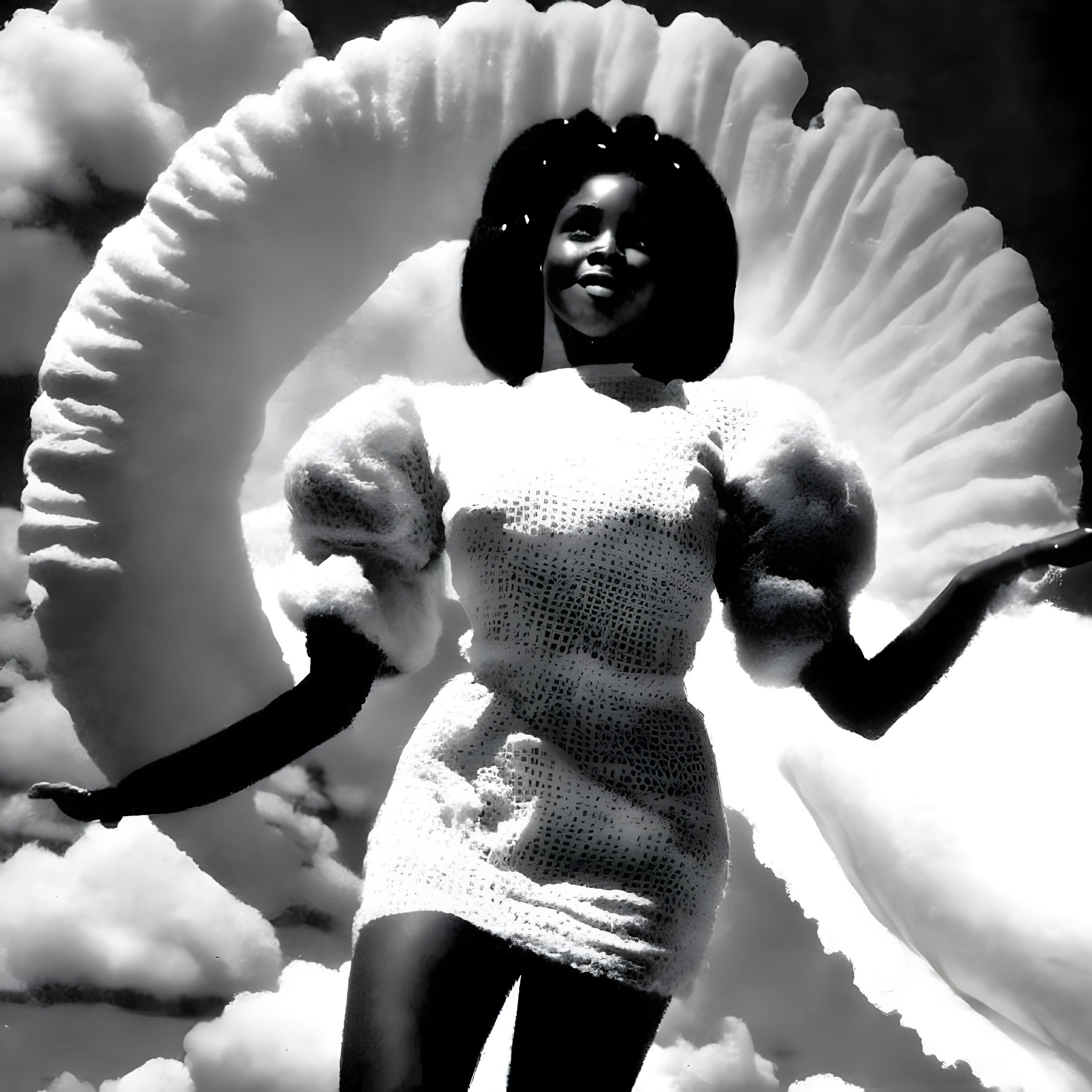 Monochrome image of smiling woman with feathery backdrop and textured dress