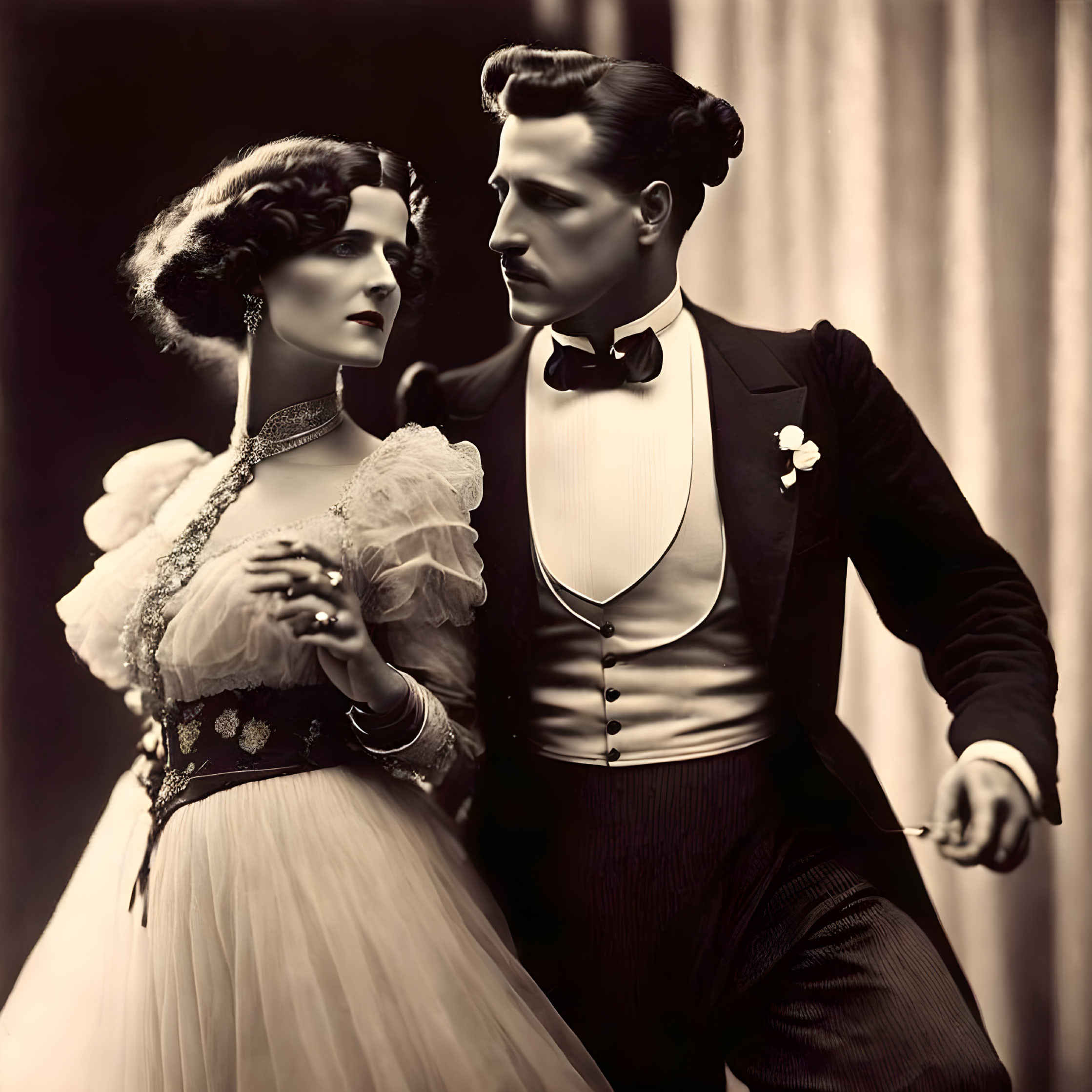 Vintage photograph: Man in tuxedo & woman in elegant dress posing gracefully