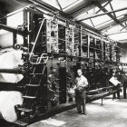 Monochrome image of people in uniform with spherical robots in futuristic setting