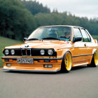 Vintage Orange BMW with Yellow Wheels on Asphalt Road