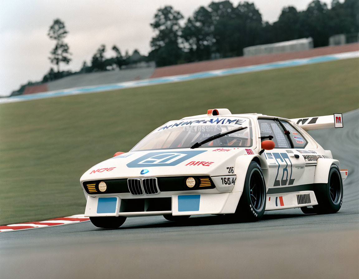 Vintage BMW M1 Race Car on Racetrack with White, Black, and Red Livery