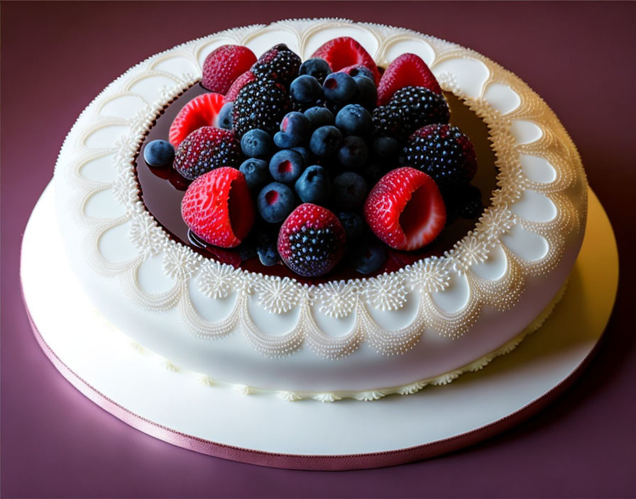 White fondant cake with mixed berry toppings and patterned border.