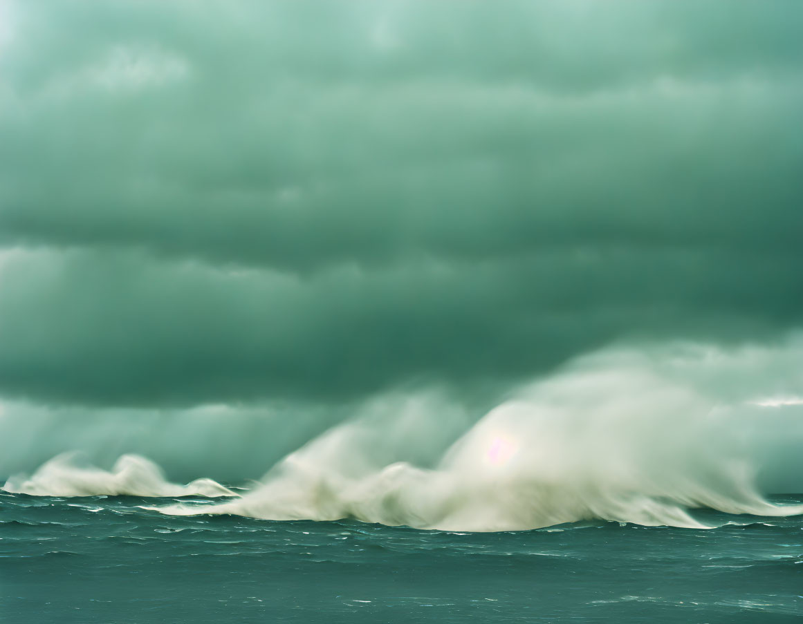 Menacing dark green storm clouds over turbulent sea with lens flare.