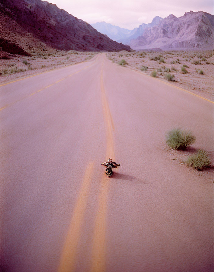 Deserted two-lane road: Motorcycle on its side