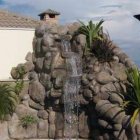 Cascading outdoor water feature with rocky landscape and cloudy sky