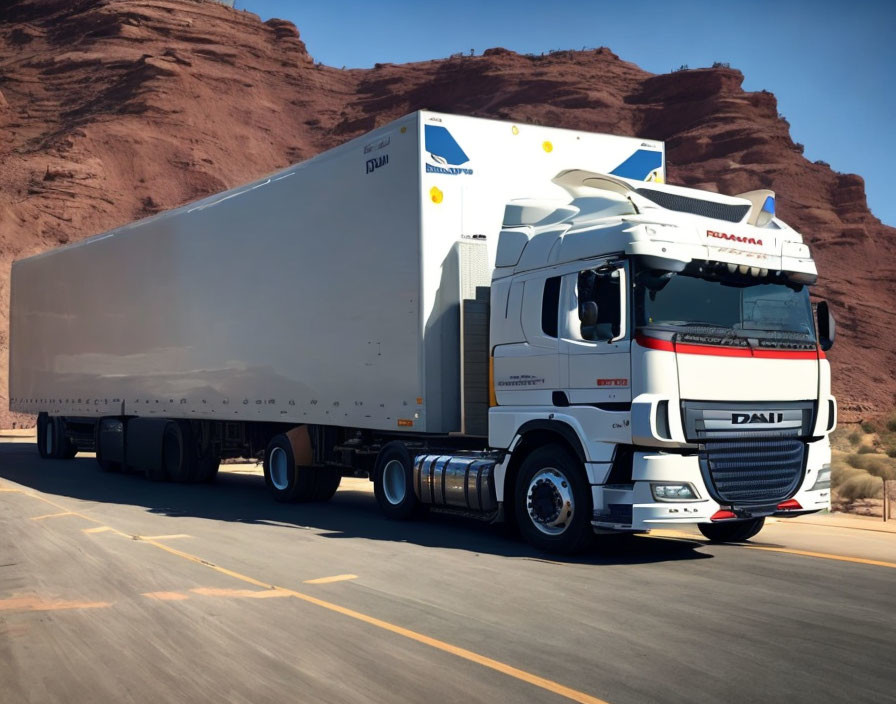 White modern semi-truck with large trailer on desert highway