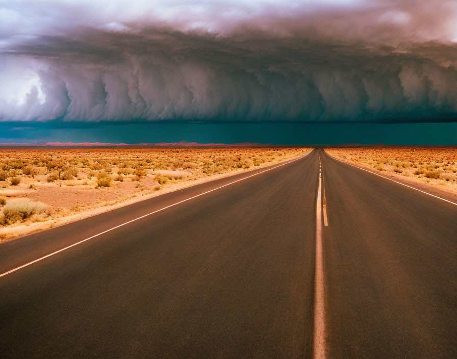 Straight Road in Arid Landscape Under Dramatic Cloud Formation