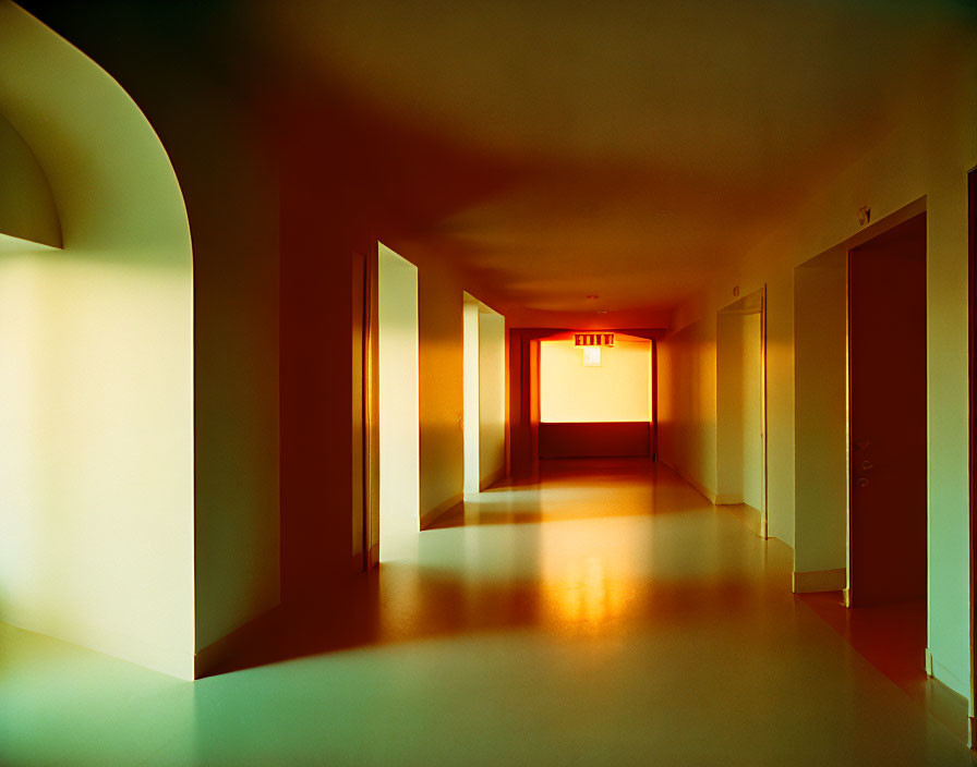 Dimly Lit Corridor with Arched Doorways and Exit Sign