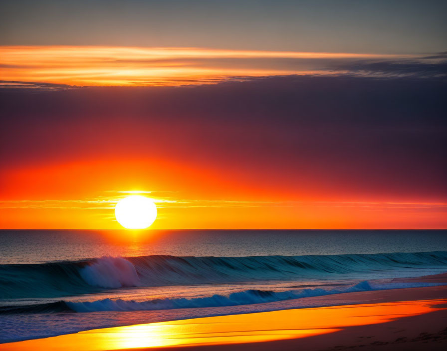 Vivid red and orange sunset over ocean with cresting waves