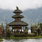 Traditional multi-tiered pavilion in serene landscape with misty mountains