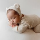 Peaceful Sleeping Baby in Cream Outfit with Lace Headband on Soft Background