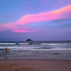 Colorful Beachscape with Purple and Pink Sky and Frothy Waves