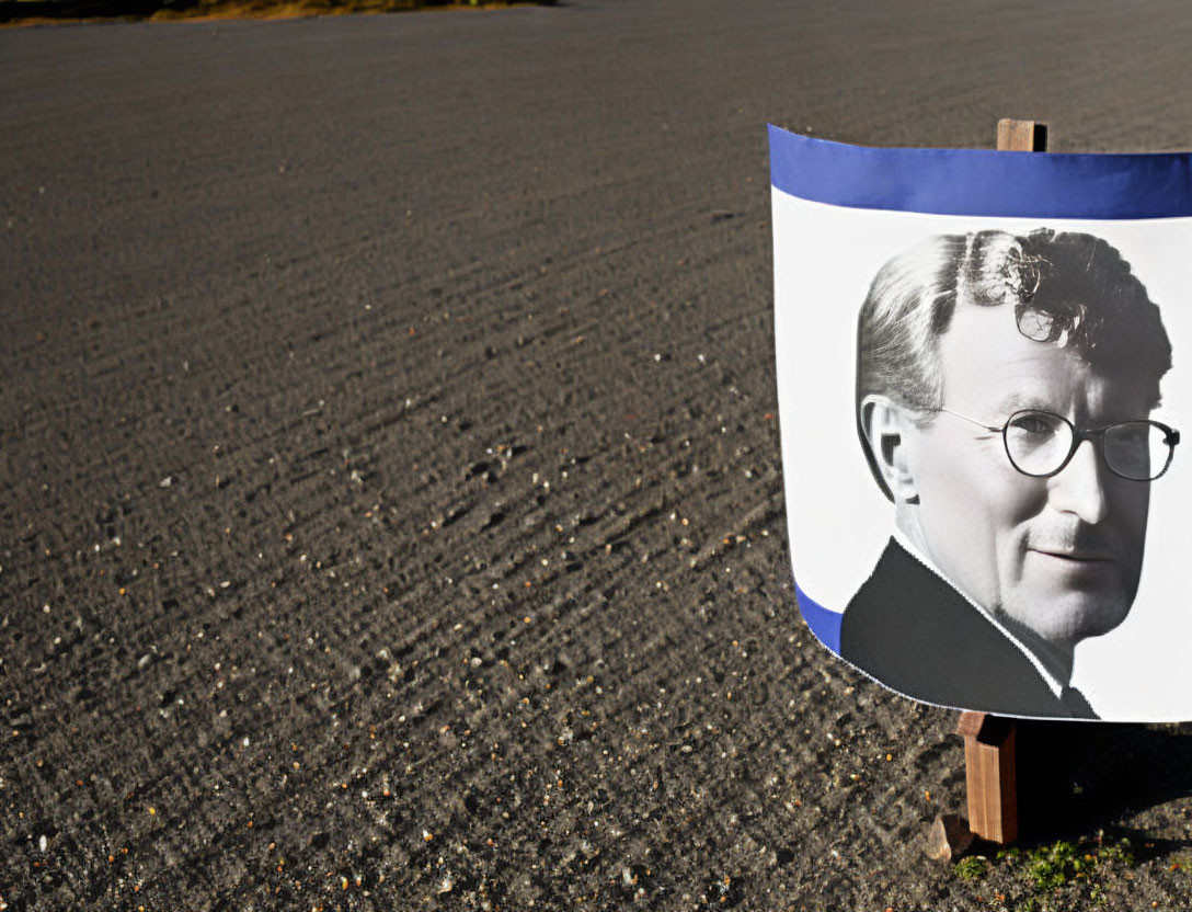 Black-and-White Poster of Man with Glasses on Textured Ground