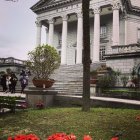 Classical building with garden, flowers, iron railing & sky