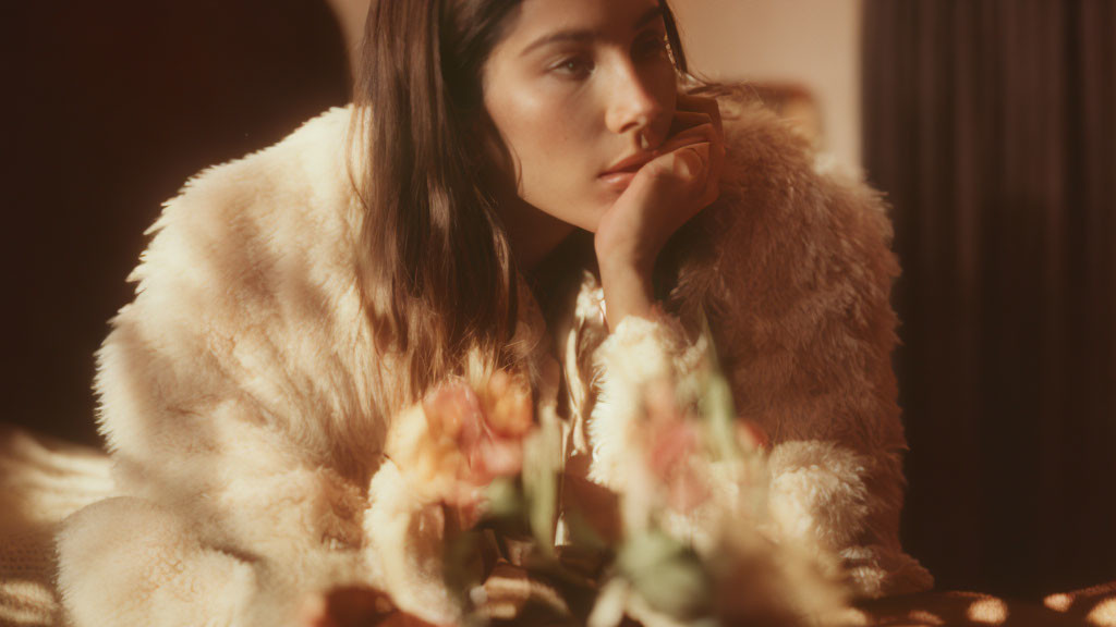 Woman in fluffy coat with flowers in soft focus