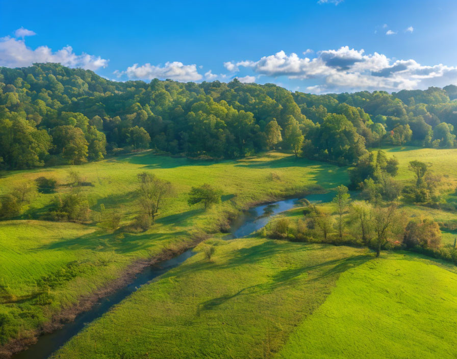 Scenic aerial view of meandering river through green fields and hills