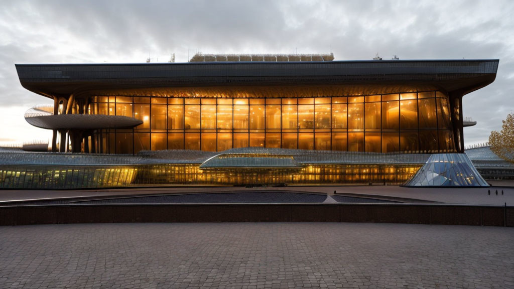 Curved modern building with glowing glass facade at dusk