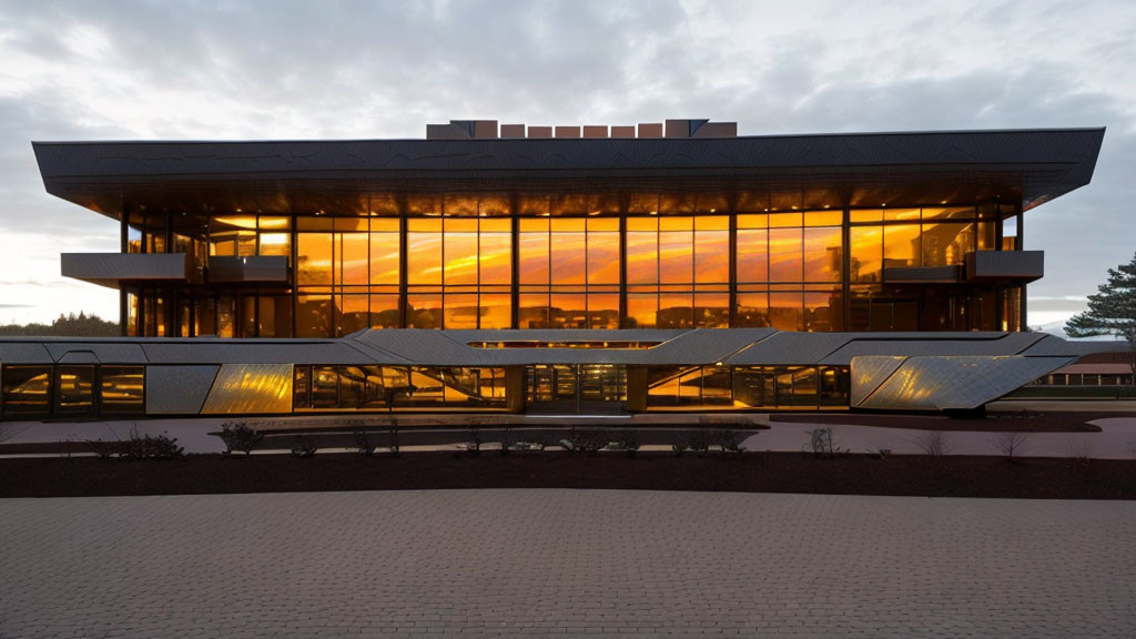 Contemporary building with glass facade reflecting sunset and angular shapes.