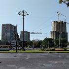 Geometric cityscape with streetlamps and lush trees under clear sky