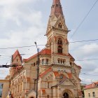 Multicolored ornate building with tall spire and arched windows