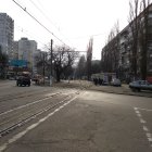 Deserted urban street with tram tracks and modern buildings.