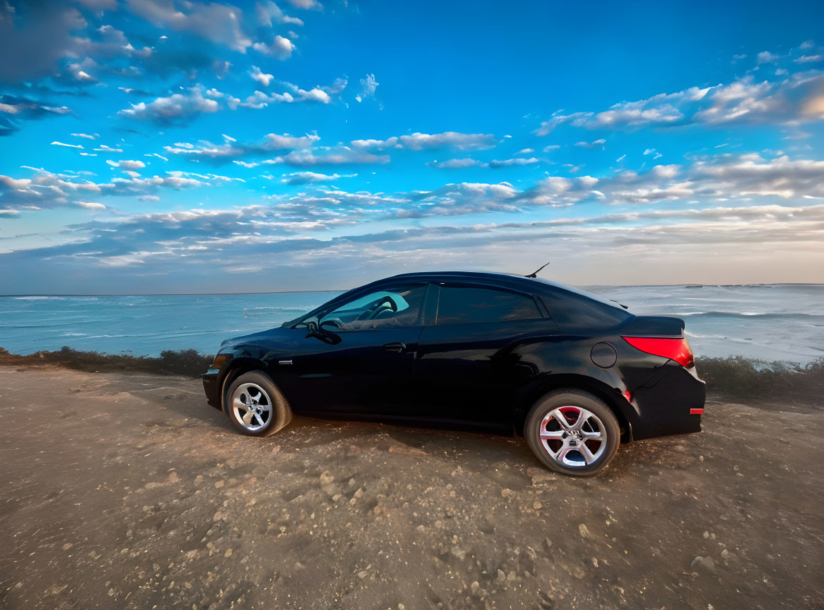 Black Car Parked on Sandy Area Near Ocean Under Blue Sky