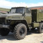 Green Military Six-Wheeled Truck with Canvas Cargo Area Parked on Sunny Day