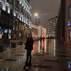 Couple walking on cobblestone street at dusk with street lamps and fairy lights.