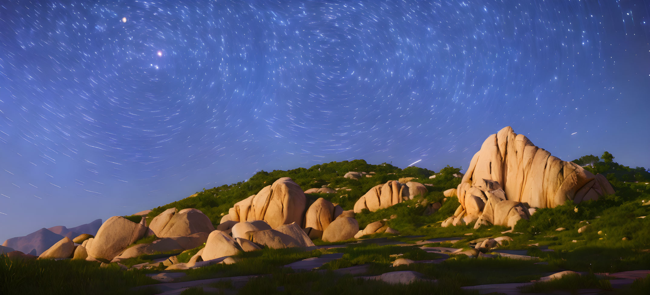 Starry Night Sky Over Boulders and Grass Hills