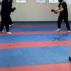 Samurai armor duel with lightsabers on red and blue mat