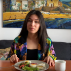 Young woman enjoying healthy meal in room with tropical beach mural