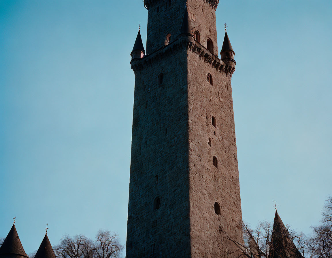 Stone tower with conical rooftops under clear blue sky