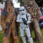 Cosplay group featuring Star Wars characters with blasters on grassy field