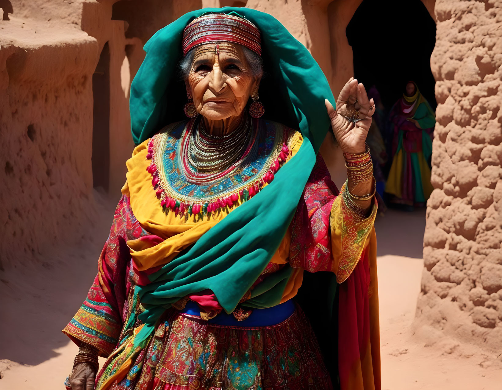 Elderly woman in traditional attire with jewelry against earthy backdrop