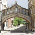 Vintage stone bridge sketch connecting classical buildings over street with trees