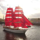 Majestic ship with red sails on turbulent golden waves