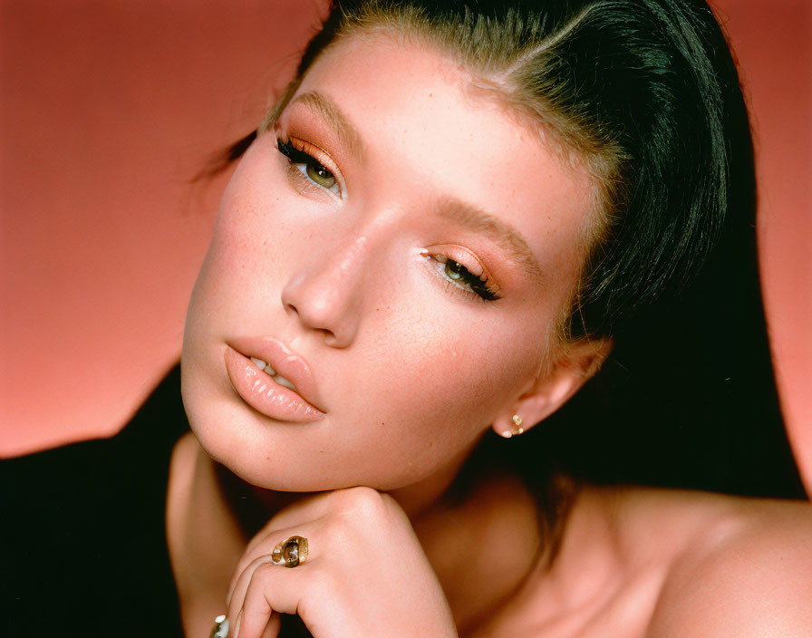 Close-Up Portrait of Woman with Shimmering Makeup and Hand on Chin