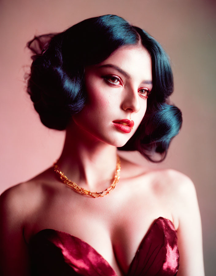 Blue-haired woman in velvet dress and gold necklace on pink background