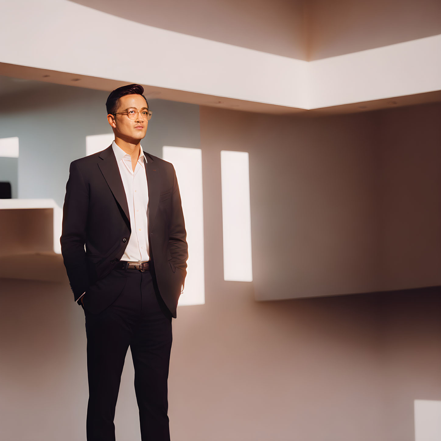 Man in black suit in modern room with geometric shadows.