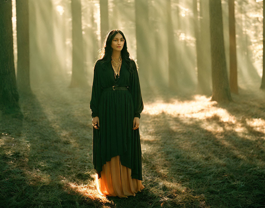 Woman in Dark Cloak in Sunlit Forest Amongst Trees