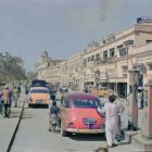 Two women in white gowns with a classic car and a multicolored bull in a misty