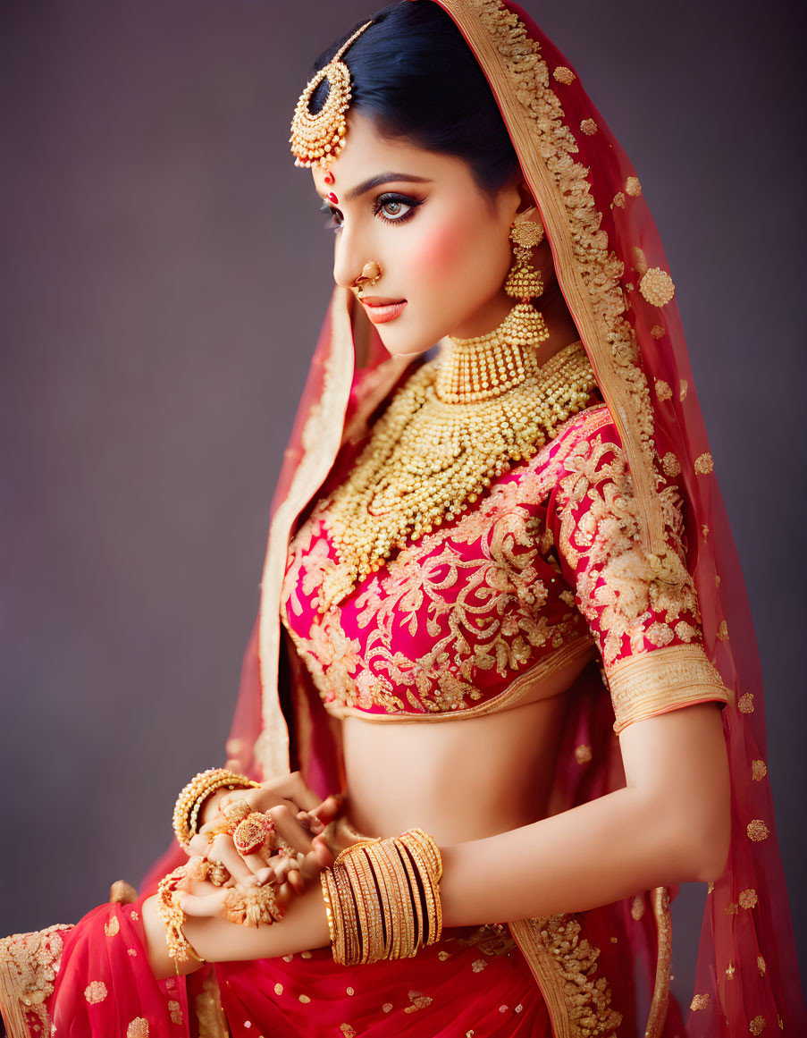 Traditional Indian Bridal Attire with Gold Jewelry and Red Lehenga