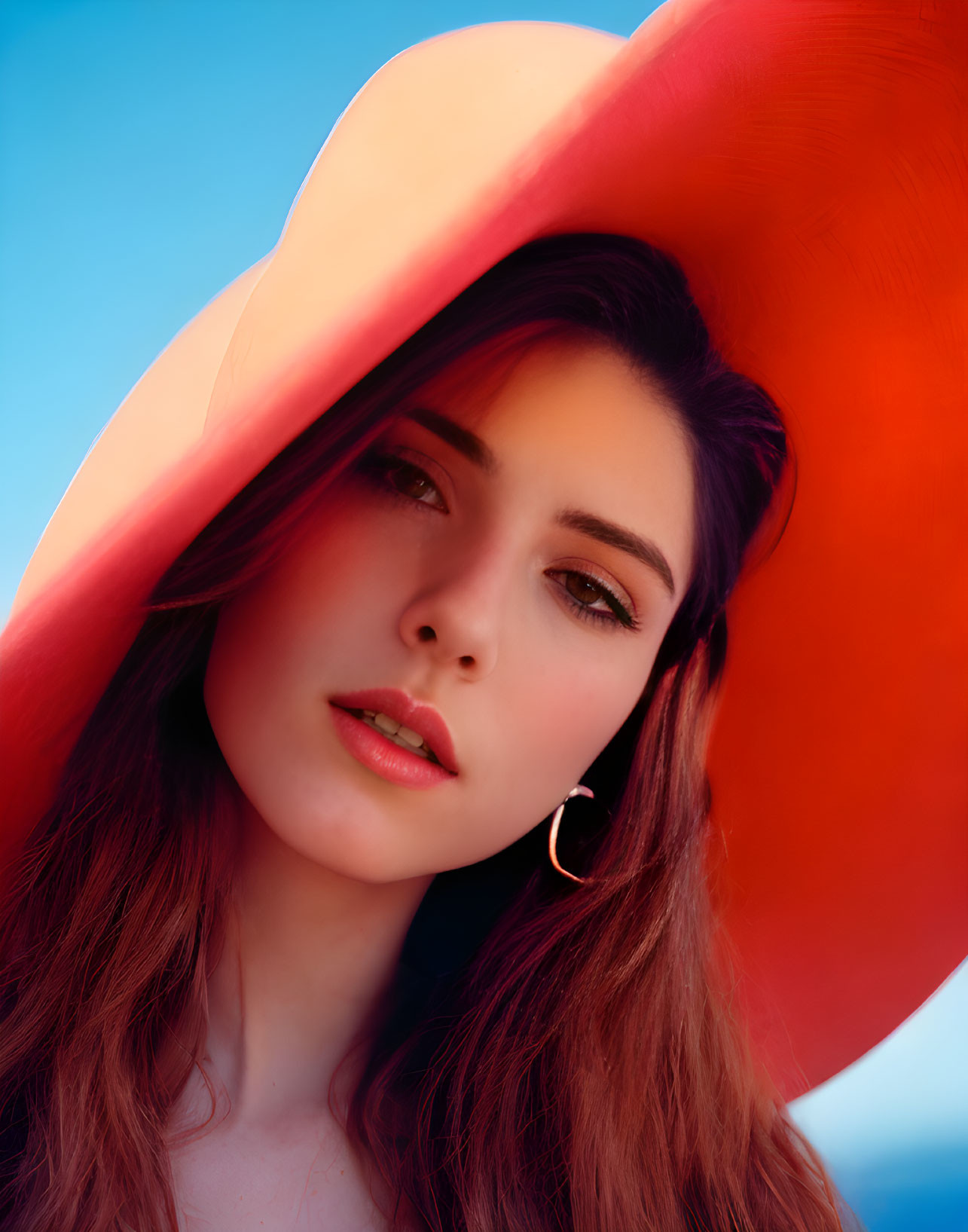 Woman with Long Brown Hair in Large Orange Hat and Hoop Earrings