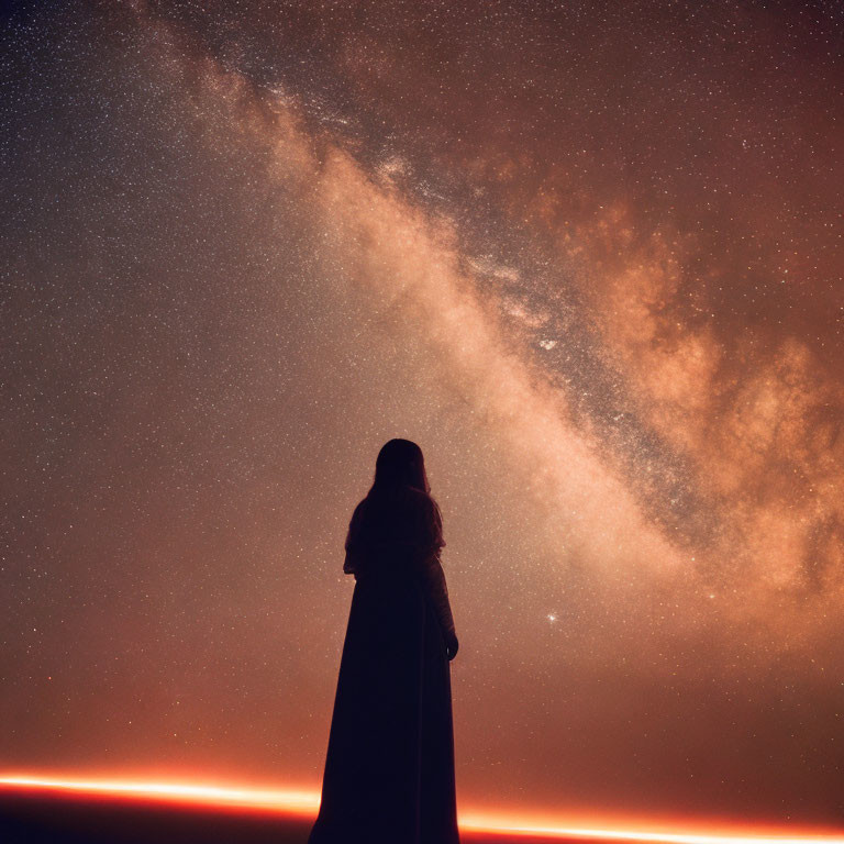 Person under starry sky with Milky Way & warm horizon glow